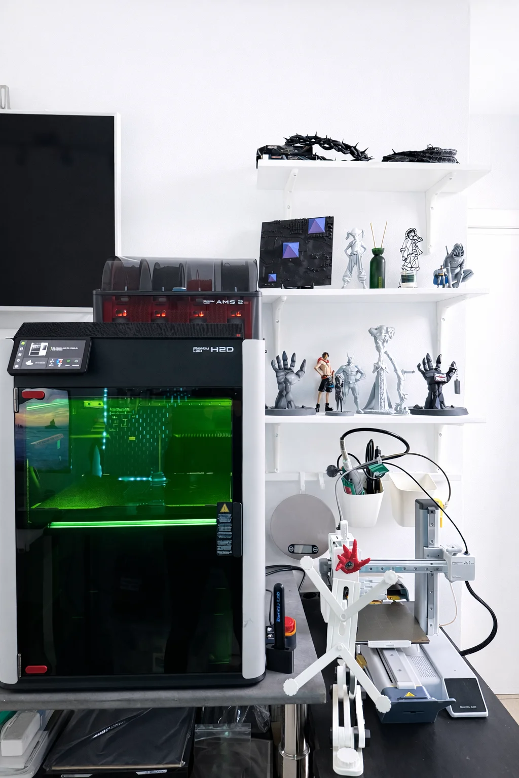 Ben's 3D printer running next to a shelf of finished pieces — workshop detail in El Médano